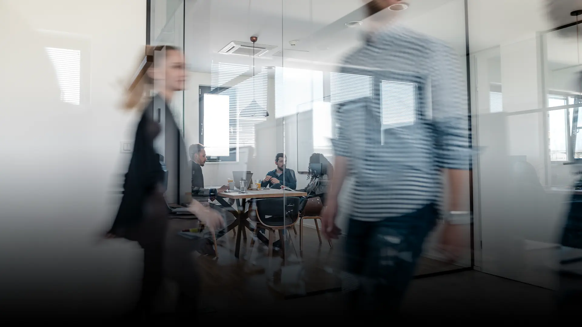 Company staff walking past a meeting room