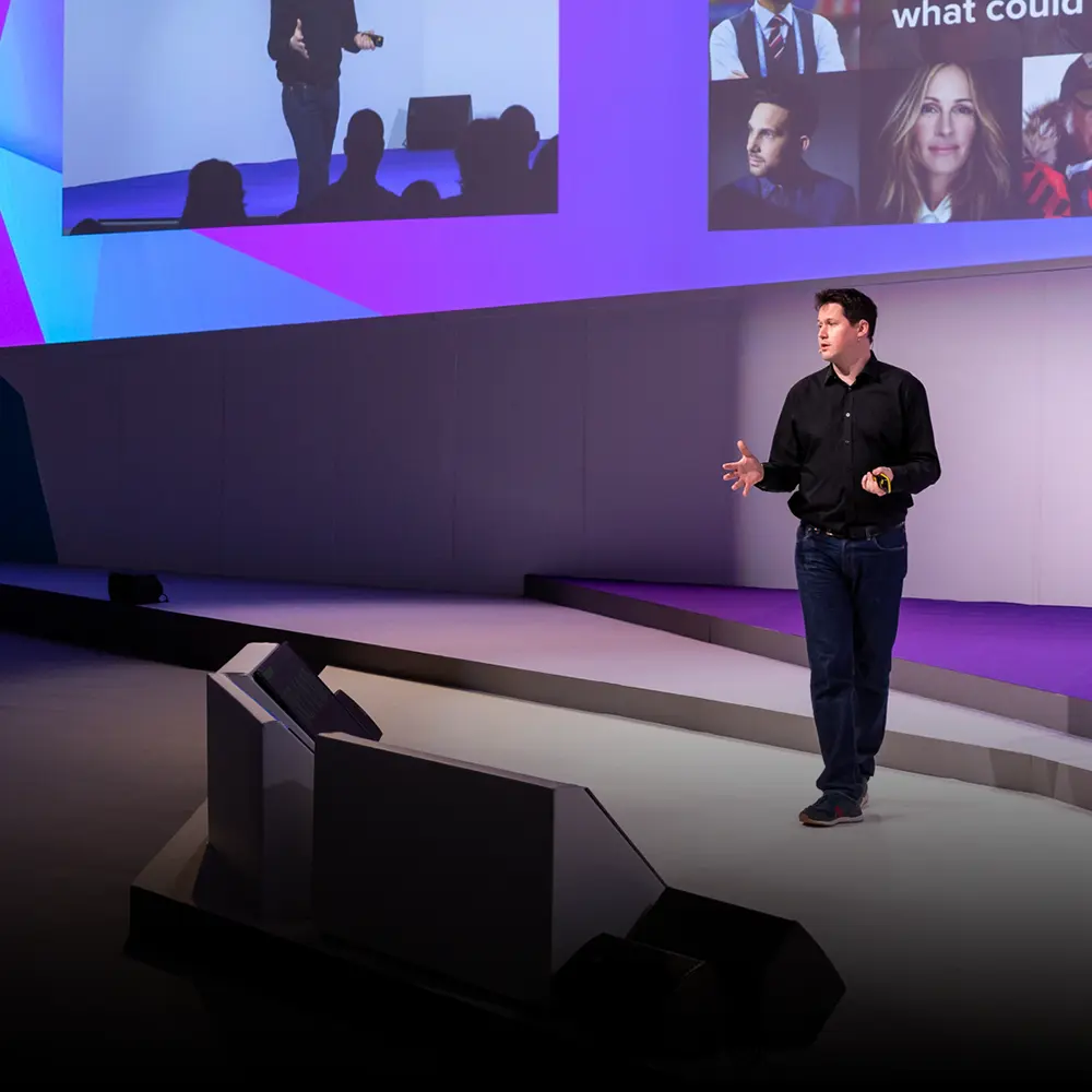 Paul Gurney, BecomingX CEO presenting on stage at an event.