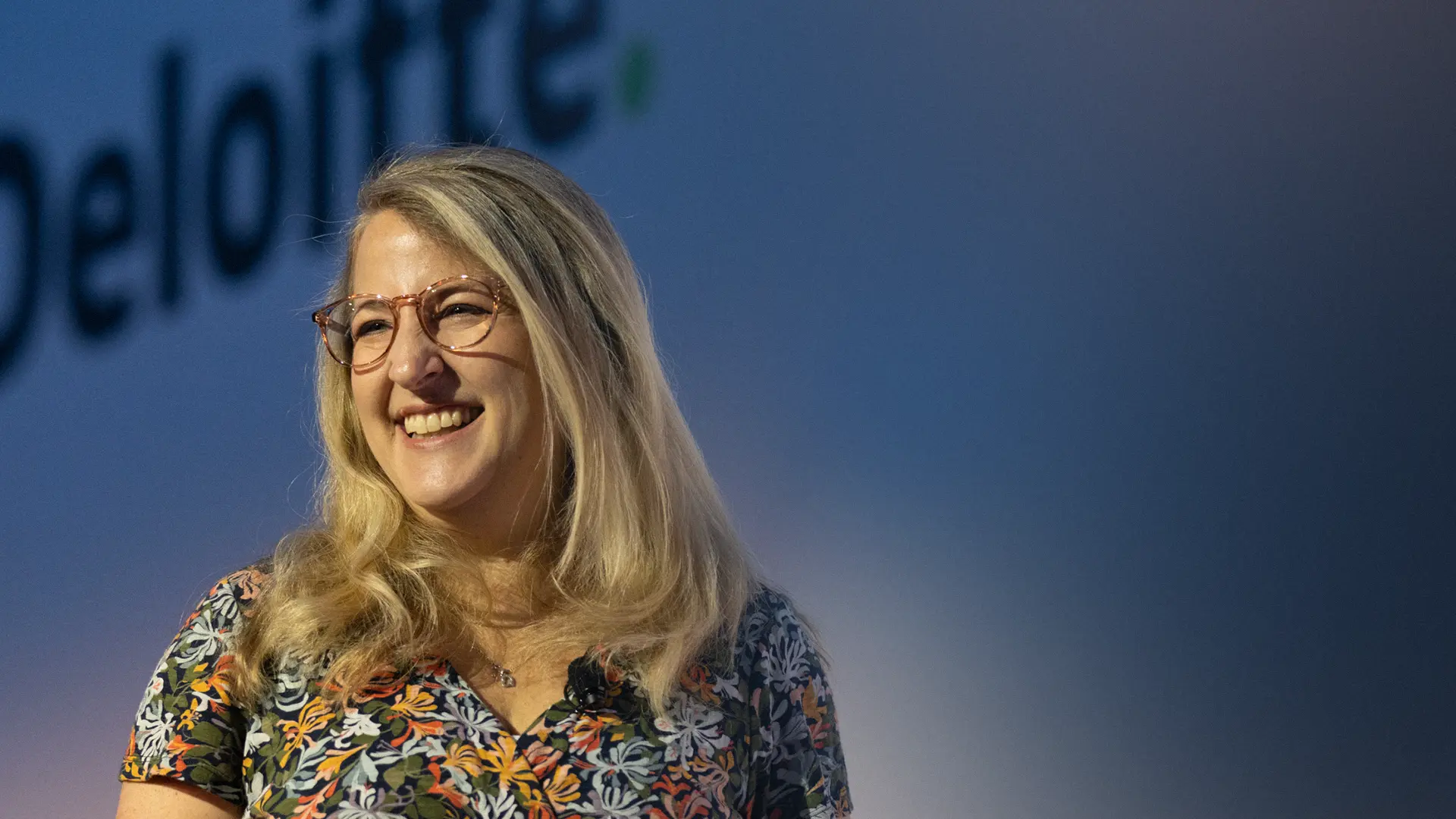 BecomingX COO Alexis Lambert on stage at an event for one of the 'big four'.